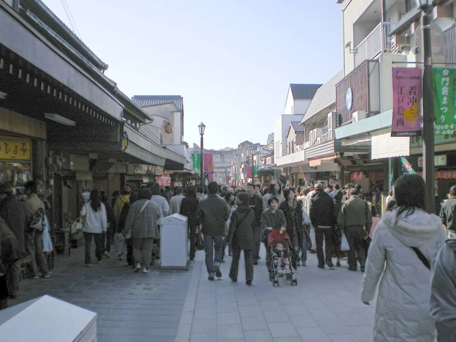 Crowds stroll the shop-lined approach to the shrine