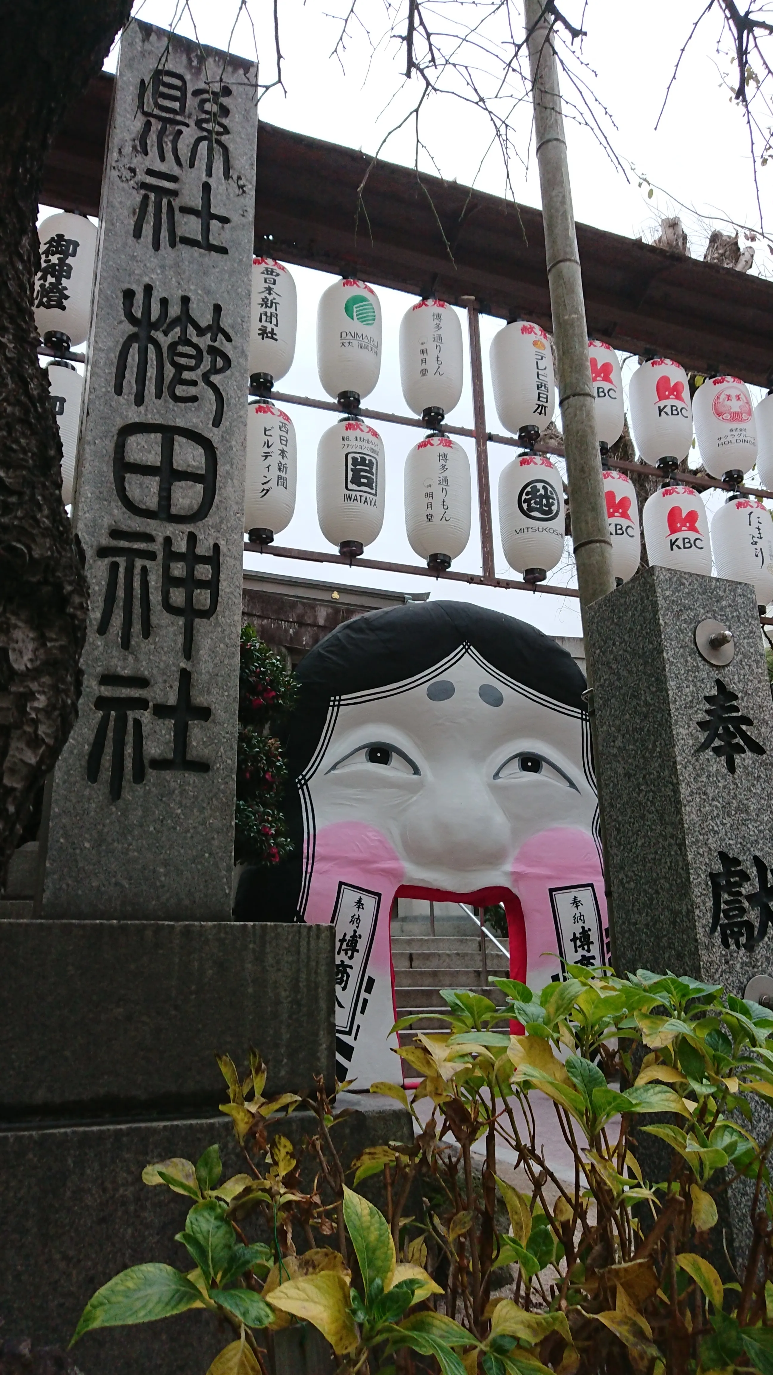 A seasonal Otafuku mask at the south gate of Kushida Shrine